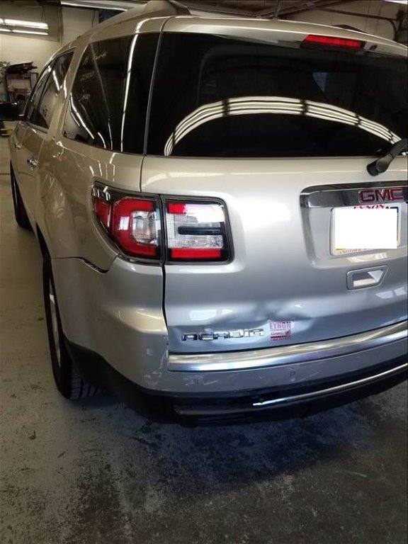 Tan GMC Acadia with dent in back