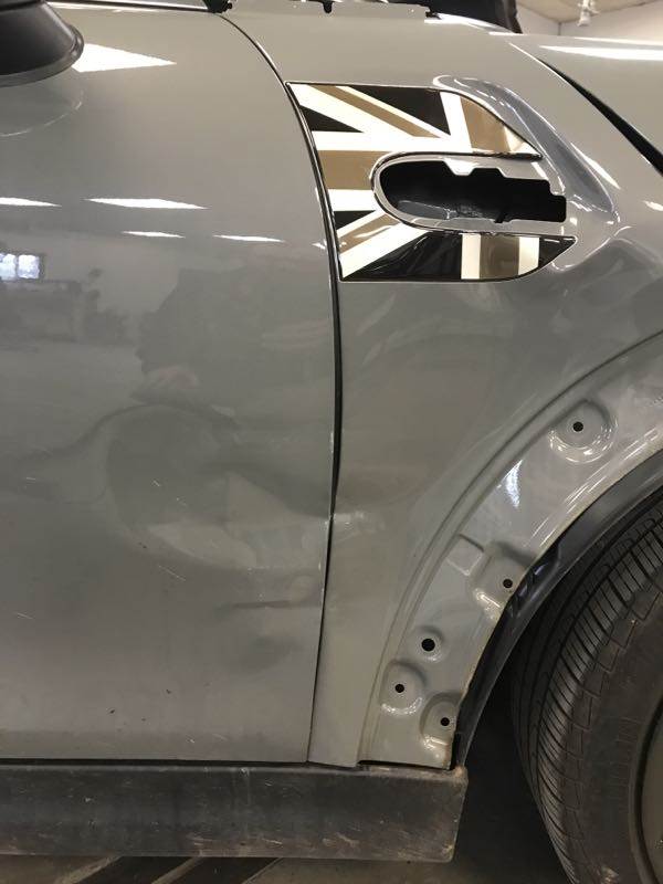 Grey Mini Cooper with dent in side