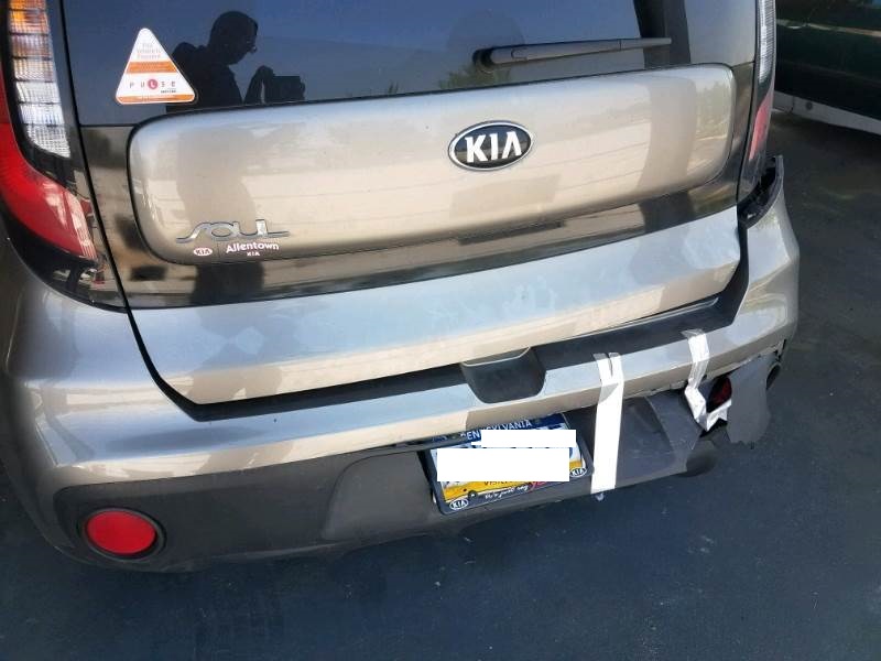 dark green KIA rear bumper damaged
